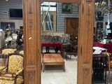 a large wooden armoire with a mirror in the middle