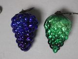 two glass grapes and a spoon next to each other