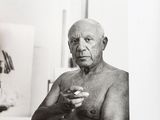 a black and white photo of an old man holding something
