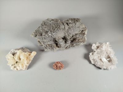 three different types of rocks on a white surface with a small piece of rock in the foreground