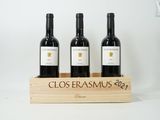 three bottles of red wine in a wooden crate on a white background
