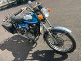 une moto bleue garée sur un parking