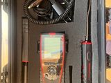 un étui noir contenant un appareil électronique rouge et noir
