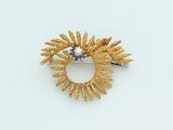 a gold brooch with a blue stone in it
