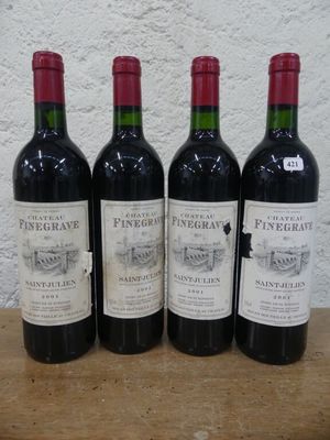 quatre bouteilles de vin sont alignées sur une table en bois