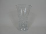 un vase en verre transparent posé sur une surface blanche