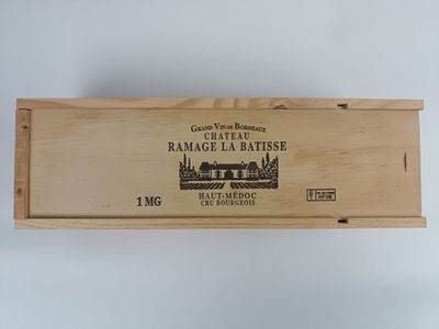 une boîte en bois vide, sur laquelle est collée une étiquette, posée sur une table