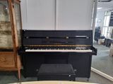 a piano that is sitting in a room with a table