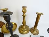 many different types of brass candlesticks on the table