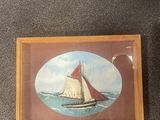 a picture of a sailboat in a picture frame on the floor