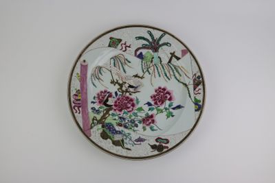 a plate with flowers and birds on it on the wall