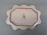a white plate with a flower on it on a table