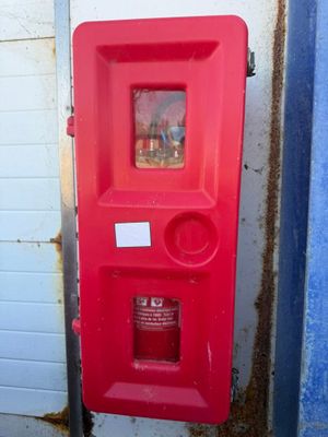 a red fire hydrant that is on the side of a building