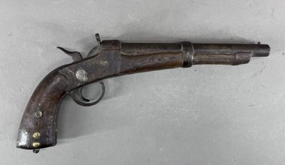 gros plan d'un pistolet sur une table à fond blanc