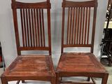 these are two wooden chairs sitting next to each other on a white floor