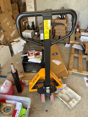 un chariot élévateur garé au milieu d'une pièce remplie de cartons