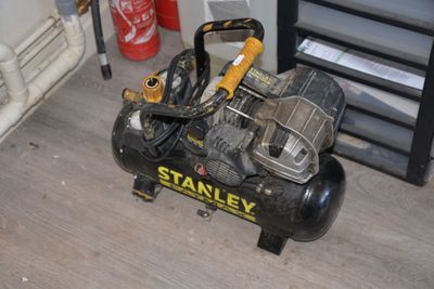 a small air compressor sitting on the floor in a room