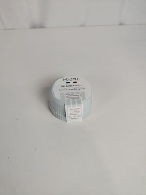 un récipient blanc muni d'une étiquette, posé sur une surface blanche