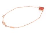 a gold bracelet with a red heart charm on it