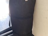 a large black bag sitting on top of a rolling suitcase