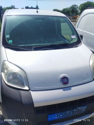 La camionnette blanche est garée sur le parking, à côté d'un camion blanc.