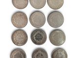six different british coins are arranged in a row on a white surface
