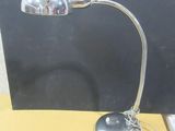 une lampe posée sur un bureau à côté d'un ordinateur portable
