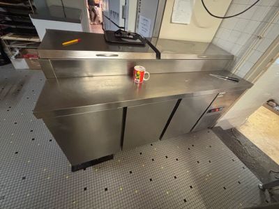 une canette de soda posée sur un plan de travail en inox
