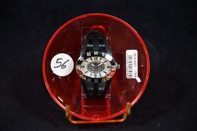 une montre dans un étui en plastique posé sur une surface noire