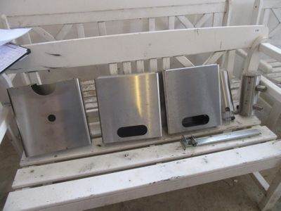 un banc blanc sur lequel sont posées trois poubelles argentées