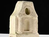 a small stone building with a window on it