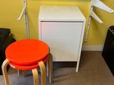 a small table with a red stool in front of it