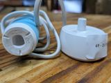 a white plug and a blue cord on a wooden table
