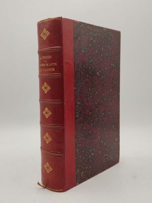 un livre rouge avec des bordures dorées posé sur une surface blanche
