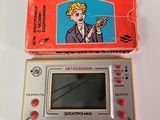 a small electronic game that is sitting next to a box