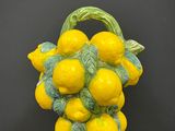 des citrons jaunes dans un panier vert posé sur une table noire