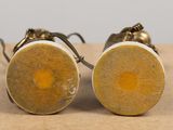 two pairs of earrings that are sitting on a table