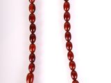 gros plan d'un collier de perles rouges sur fond blanc