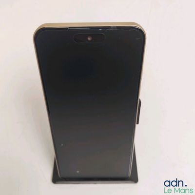 a close up of a black phone on a stand on a white surface