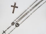 rosary and cross on a white table with a white background