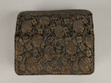 an antique black and gold brocadel purse on a white surface