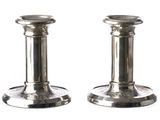 une paire de bougeoirs en argent sur fond blanc, avec un fond blanc