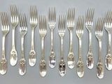 six forks and six spoons are arranged in a row on a table