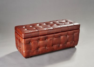 boîte en cuir marron sur fond gris, avec une ombre sur le sol
