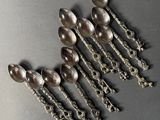 six silver spoons are arranged in a row on a gray surface