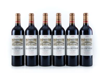 quatre bouteilles de vin rouge sont alignées sur une surface blanche