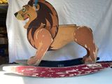un jouet en bois représentant un lion debout sur un skateboard