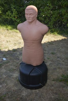 une statue représentant un homme assis sur un tabouret noir