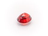 a close up of a red diamond on a white surface