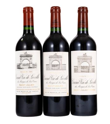trois bouteilles de vin rouge posées l'une à côté de l'autre sur une surface blanche